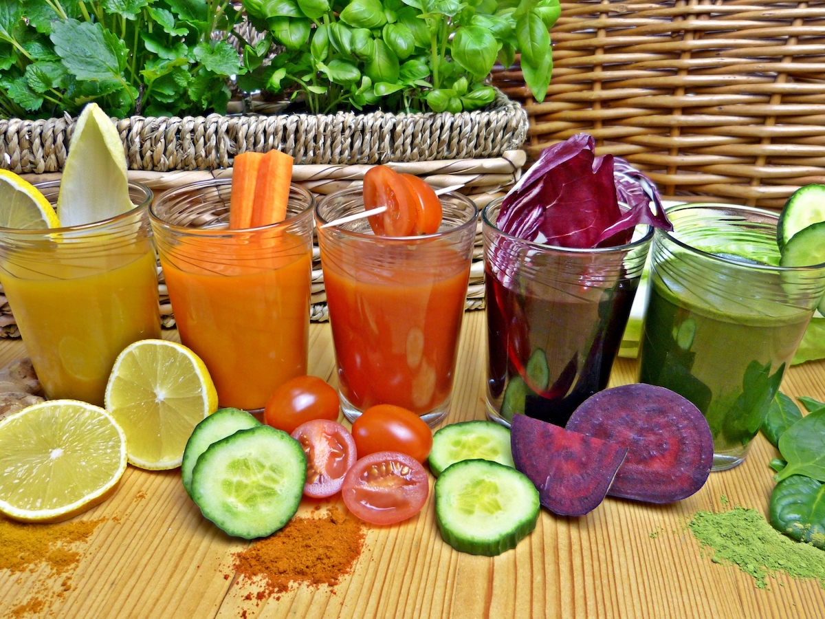 Fresh fruit juice in glass cups, yellow juice, orange carrot juice, tomato juice, purple cabbage juice, Can you freeze fresh juice from a juicer?